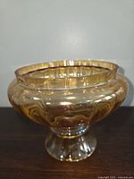 Amber glass lamp shade showing rounded and ribbed bulbous form and pedestal base