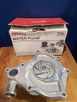 Photo of new GMB water pump with impeller and original GMB branded box labeled Water Pump OE and model 180-2210.