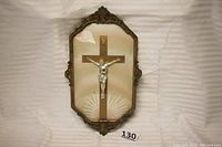 Full view of antique crucifixion plaque showing ornate steel frame with brass adornments and bubble glass cover