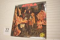 Front cover of Attila vinyl record showing two men in barbarian clothing among hanging meat