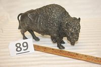 Photo of the bison desk statue showing its full side profile with a ruler indicating length.