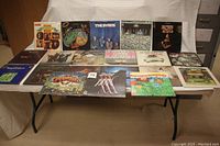 Twenty vinyl albums displayed on table, showing front covers and some backs.