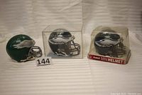 Three signed Philadelphia Eagles mini helmets: Mike Quick helmet without box, Reggie Brown helmet in Riddell box, Omar Gaither helmet in clear display box.