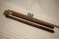 Wooden cane separated into two parts with measuring ruler. Shows overall length and segmented design.