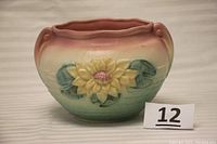 Front view showing water lily flower raised decoration and scalloped pink rim.