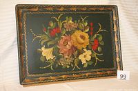Full view of wooden serving tray with hand painted floral design on black background and decorative border.