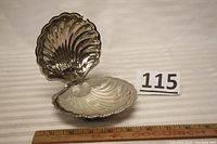 Open silver-plated clam shell butter dish showing interior details and hinge mechanism.