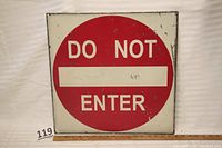 Front view of the vintage steel Do Not Enter sign showing red circle with white text and wear marks