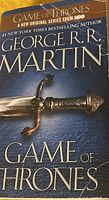 Front cover of the paperback book 'Game of Thrones' by George R.R. Martin, showing the HBO series reference and sword cover art.