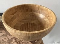 Top and side view of a round wooden bowl with a patterned wood grain surface, smooth finish, and moderate depth.