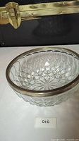 Crystal bowl with silver rim viewed from the side showing cut crystal design and metal rim.