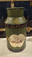 Front view of large vintage milk can showing detailed hand-painted farm scene and floral designs on green background with raised letters