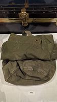 Photo of folded olive green military duffel bag showing front side and strap