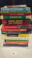 Stack of 16 music business and songwriting books with colorful spines shown from side view