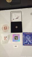 Overview photo of the Millennium coin set including coin in display case and collectible cards