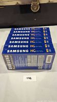 Seven sealed Samsung High Grade T-120 VHS tapes stacked horizontally showing labels and packaging details