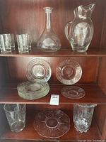 Detailed shot of various pieces including serving plate and vases on bottom shelf.