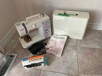 Overview of sewing machine, foot pedal, manual, case and buttonholer box