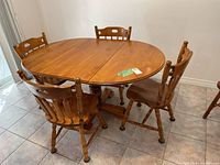 Complete wood pedestal round kitchen table with four matching chairs.