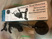 Discriminator Metal Detector laid next to its original Radio Shack box showing product name and images.