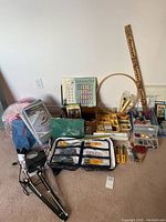 Wide view of the sewing and quilting tools, fabric, and accessories spread on the floor showing all items in the lot