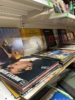 Shelf with stacks of vintage vinyl records including Supertramp, Johnnie Taylor, The Police, and more.