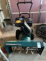 Front view of Dynamark Plus by Noma snowblower showing auger and front housing with branding decal.