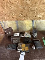 Overview photo showing all items in lot including Bell & Howell camera, Kodak camera, cases, flash, film cartridges, instruction manuals, and accessories on table.