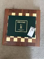 Chess set box on top of the chess board showing the Drueke logo and brand