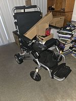 Full three-quarter front view of Air Hawk wheelchair folded and unfolded in living room