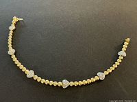 Full length of bracelet laid flat on black background