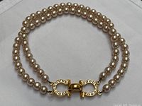 Two-row faux pearl necklace with clasp visible