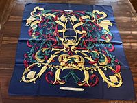 Full view of scarf laid flat showing complete baroque equestrian motif on navy blue ground