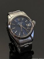 Front view showing blue dial, hands and cyclops date window.