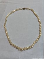 Full 19.5-inch strand of uniform round cream-colored pearls.