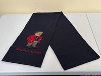 Full view of navy scarf folded to show overall knit and bear motif