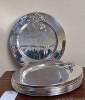 Stack of nine plates with one plate upright displaying overall shape and design