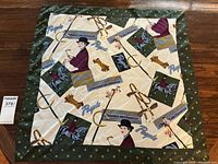 Full view of scarf showing vintage inspired prints on cream background with green polka dot border.