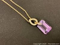 Close-up of emerald cut purple amethyst pendant with diamond-set gold bail on fine gold chain