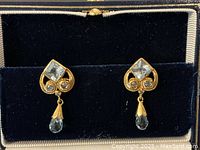 Pair of earrings displayed in navy velvet box, front view