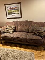 Side view of the 3 seater sofa couch showing patterned upholstery and one matching striped throw pillow.