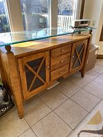 Front view of wooden side hutch with glass top, drawers and cabinets