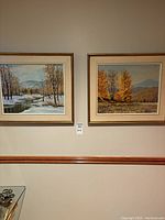 Both Hans Pirl Laurentian landscape paintings, fall and winter scenes, hung side by side on a wall