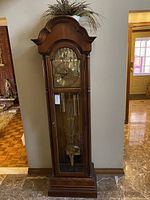 Full front view of clock with faux plant on top