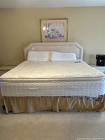 Full view of king bed set showing upholstered headboard, mattress, box spring and pillows