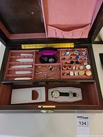 Open jewelry box showing metal collar stays, tie pins, cuff links, shirt studs and Armitron Peanuts watch inside lower compartment