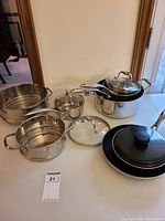 Full set laid out on table showing pots, pans, lids and inserts