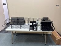 View of all 22 desk filing organizers arranged on a table, showing a variety of black metal and plastic units.