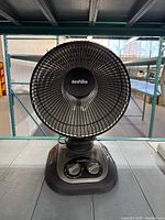 Front view of Duraflame electric heater showing circular black grill and control knobs on base