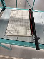 Front view of Boston paper cutter showing 15 inch grid cutting surface and handle.